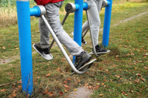 People trying out outdoor gym exercise equipment for the first time